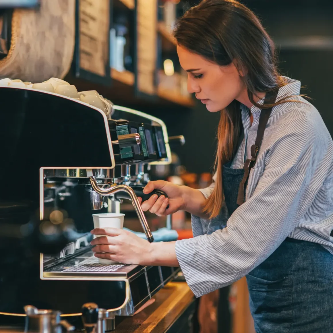 barista brewing macchiato in an espresso machine