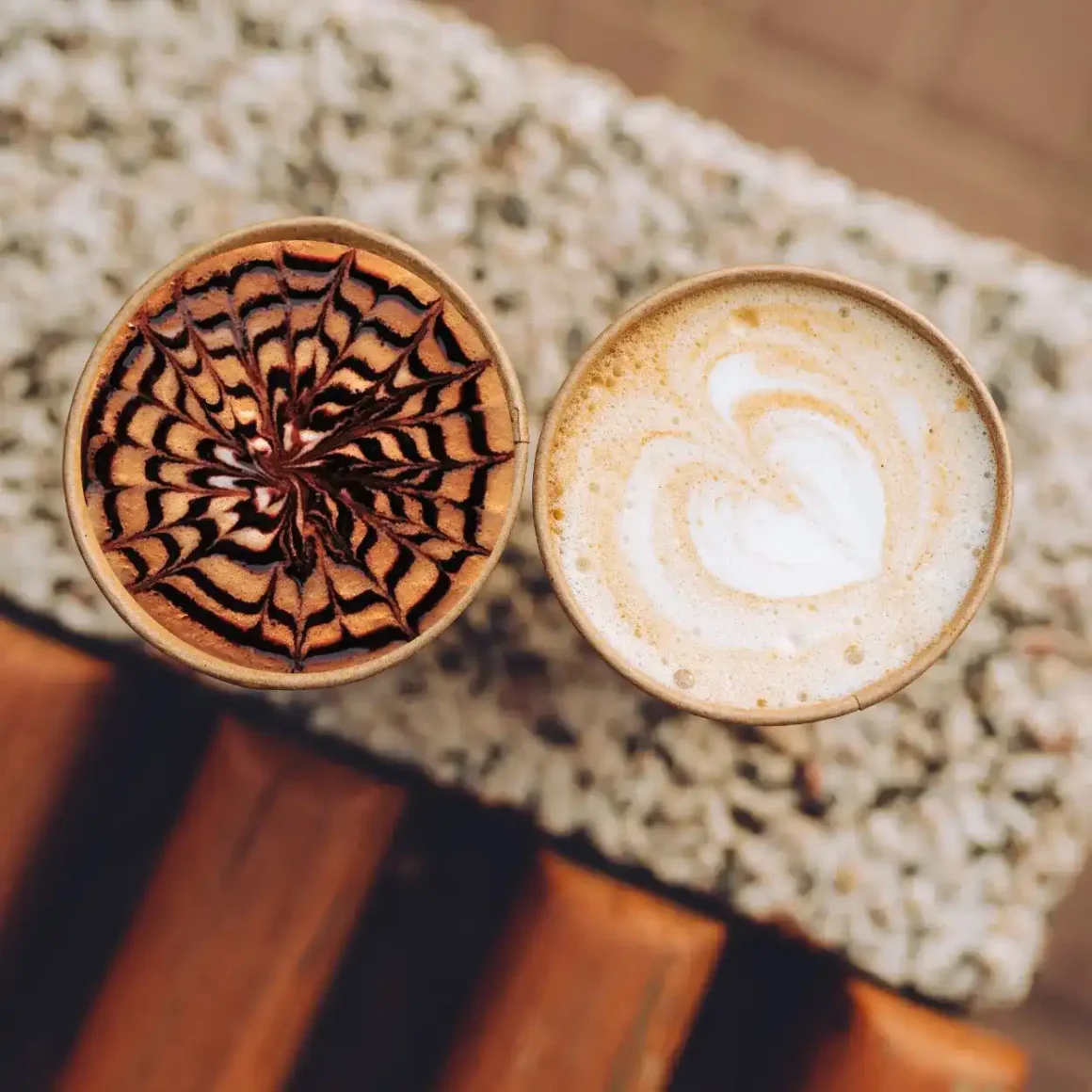 two cups of mocha and latte with design on top