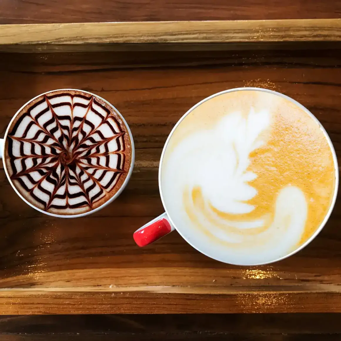 two cups of mocha and latte on a wooden tray