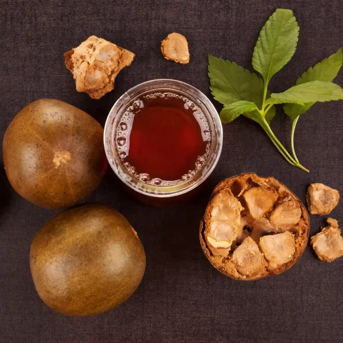 a glass of monk fruit extract next to monk fruits