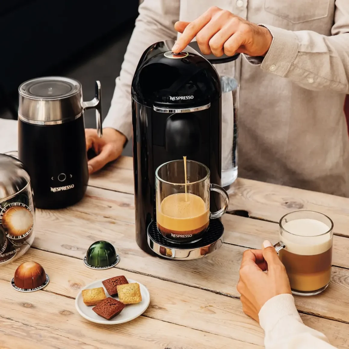 barista brewing coffee in a nespresso machine