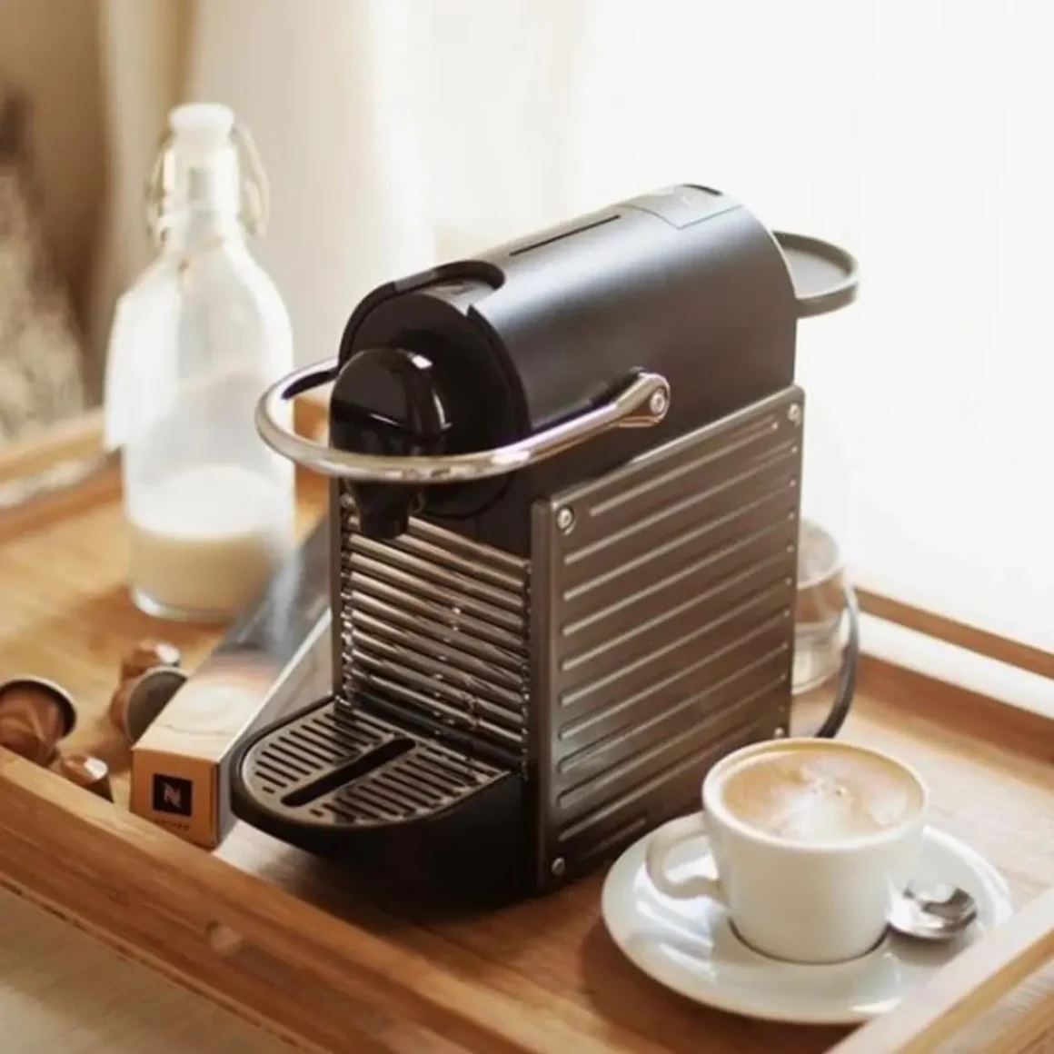 a nespresso citiz espresso machine and a cup of coffee on a tray
