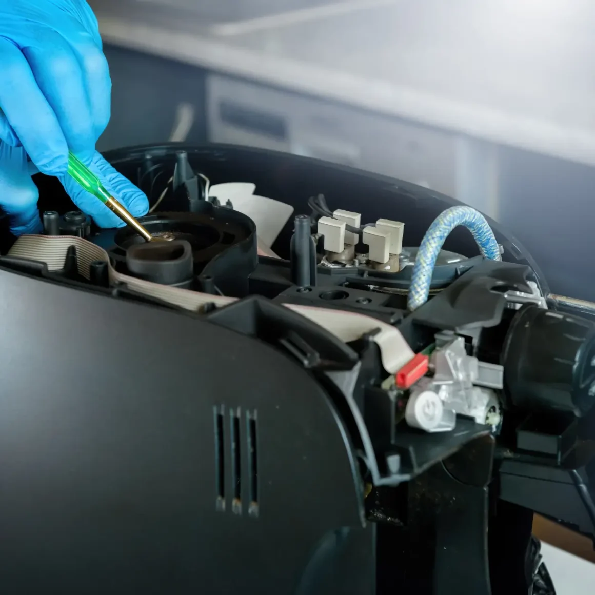a person's hand in blue gloves fixing a nespresso citiz espresso machine