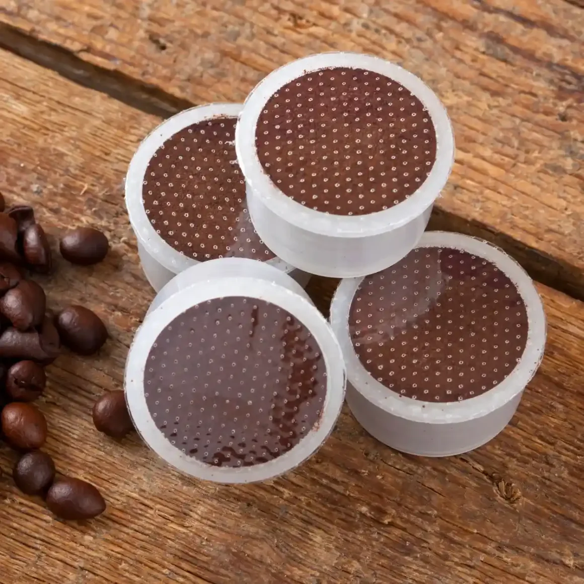 a group of coffee pods and coffee beans on a wood surface