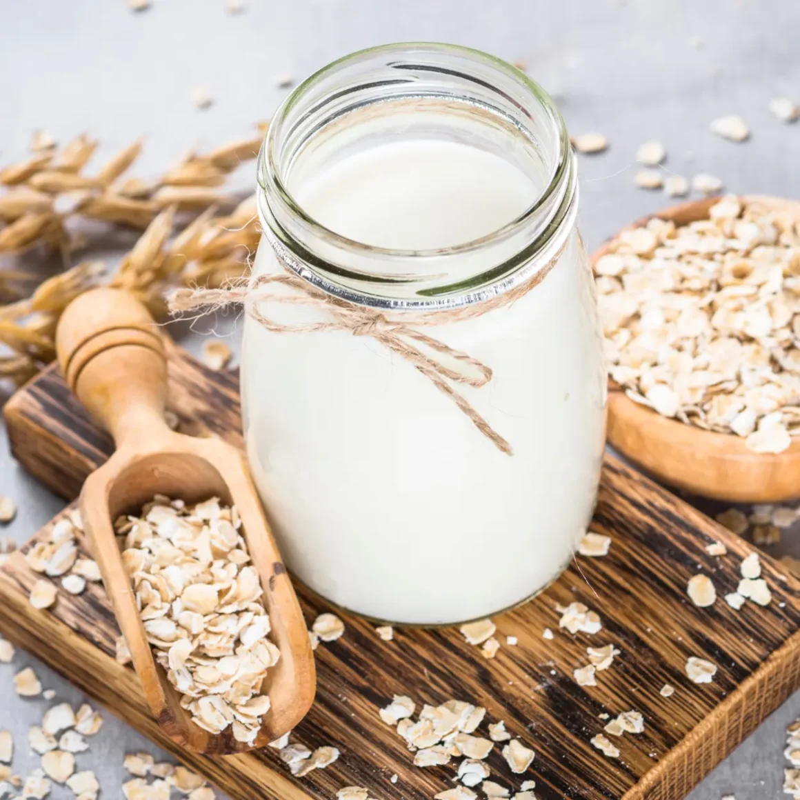 a glass jar of oat milk and a bowl of oats