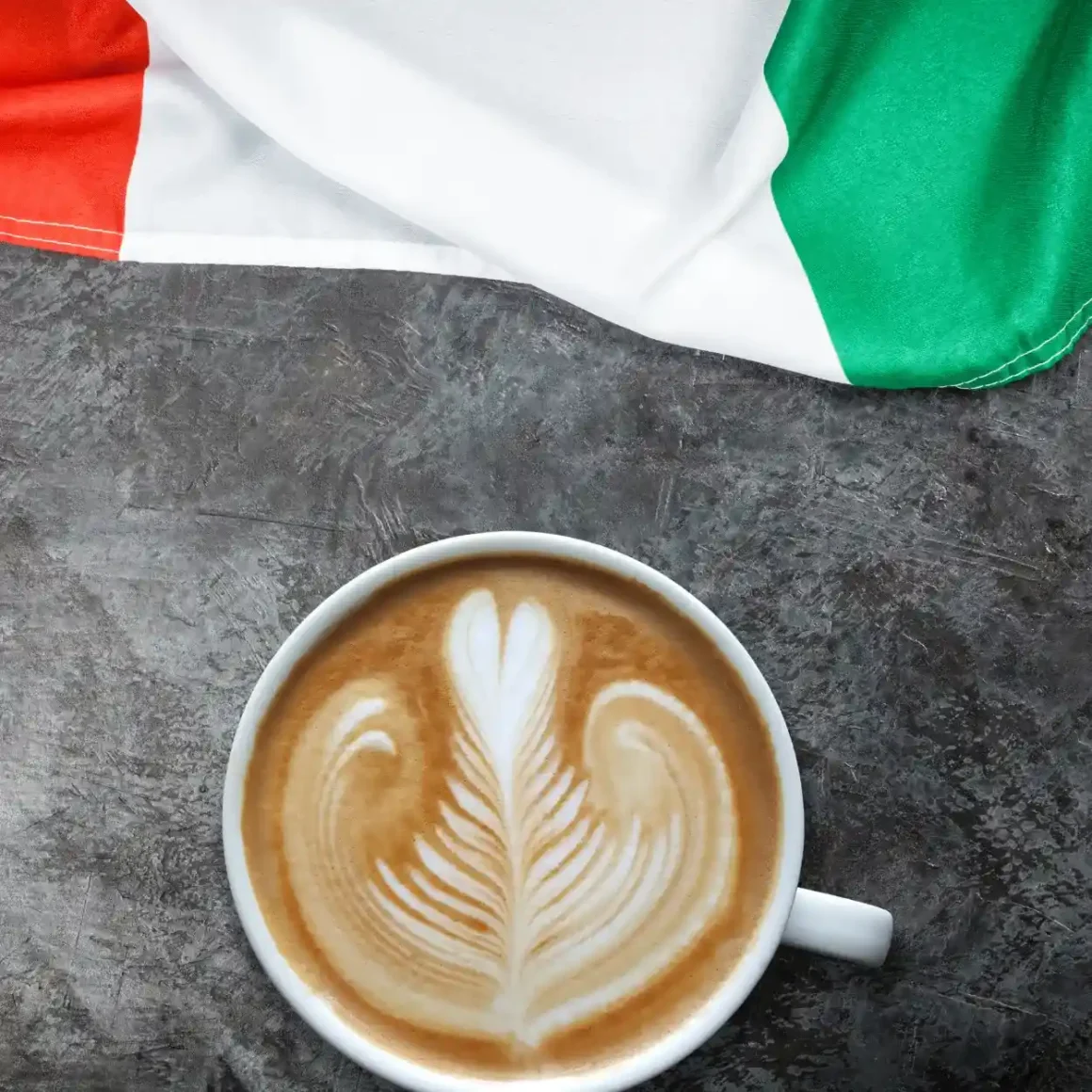 a cup of latte with a leaf design on top of it
