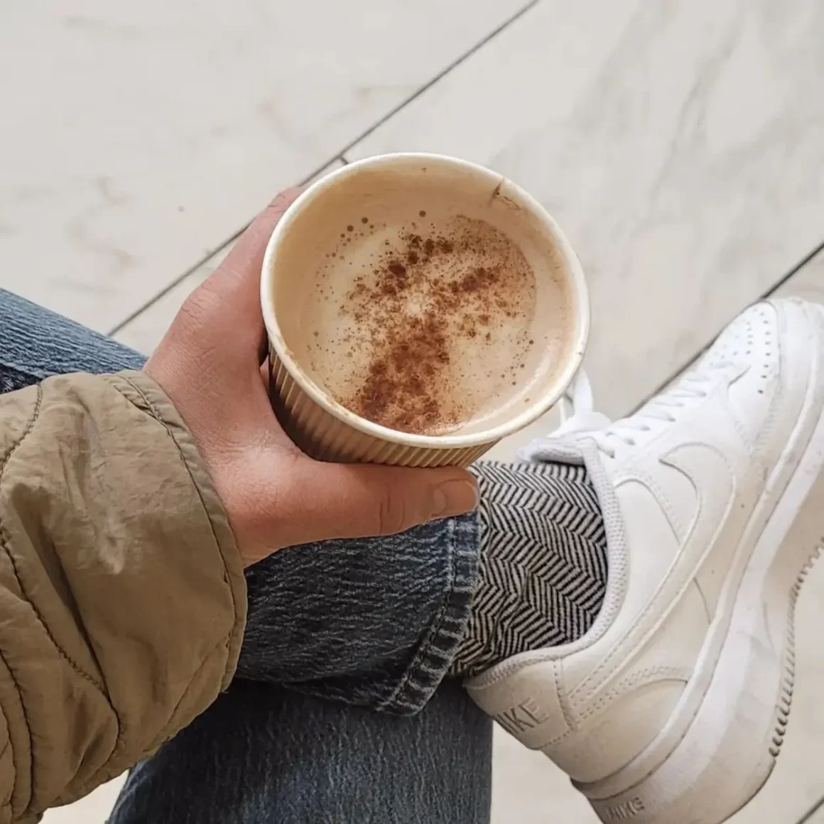 a person holding a cup of cafe con leche