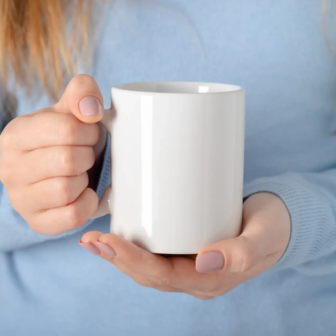 a person holding a white porcelain mug
