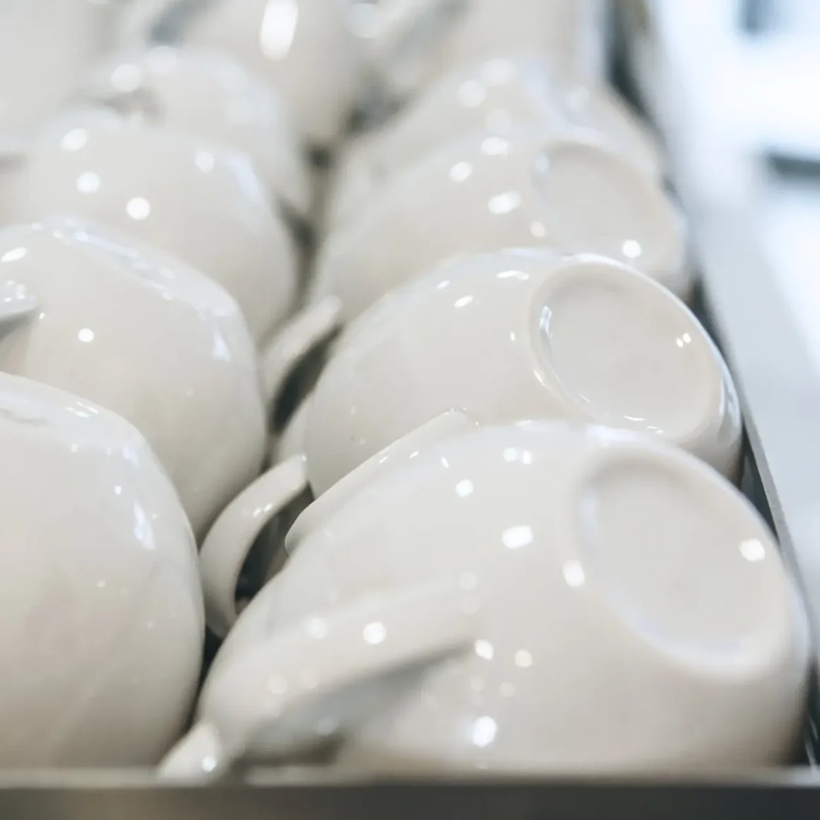 a group of white porcelain mugs