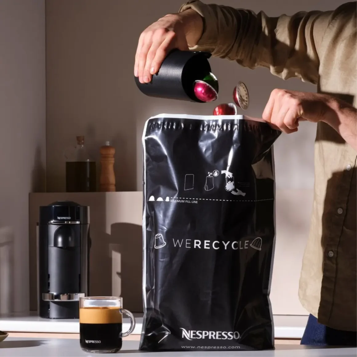a person pouring nespresso pods into a bag