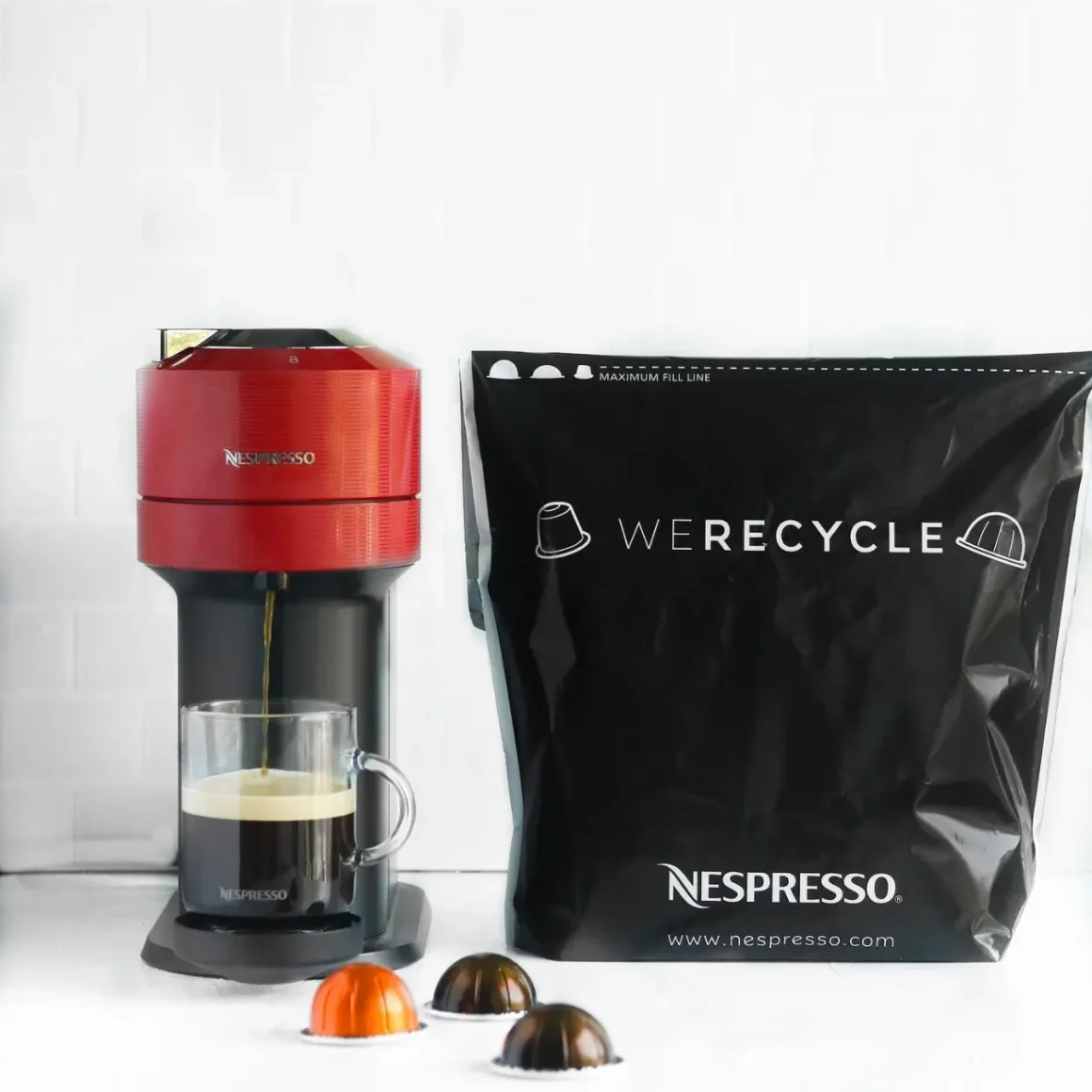 a coffee maker and a recycling bag of nespresso pods