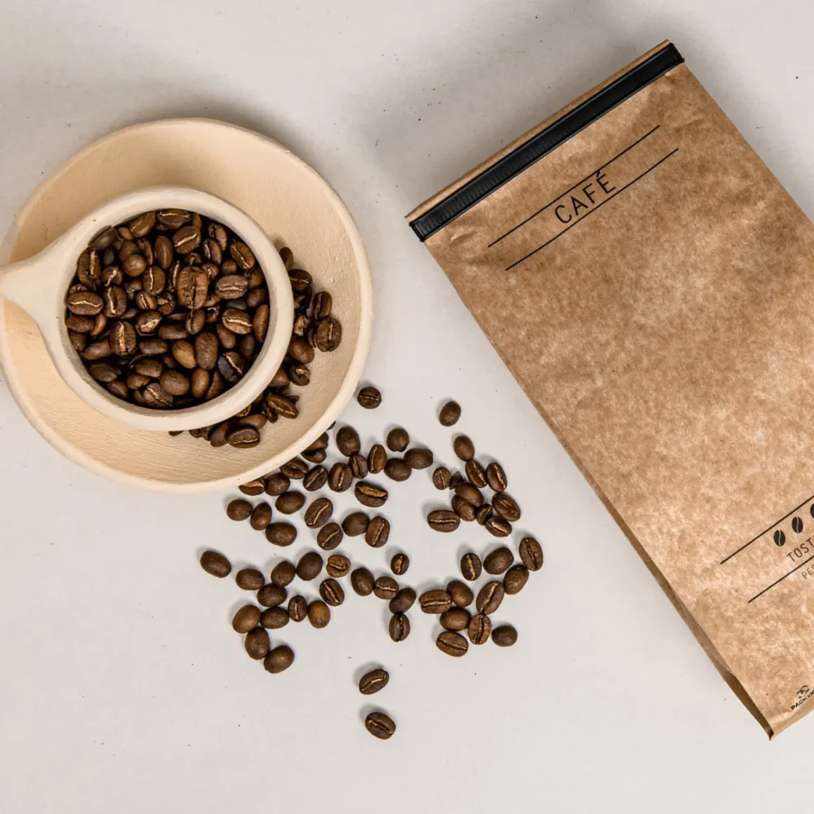a cup with coffee beans and a bag