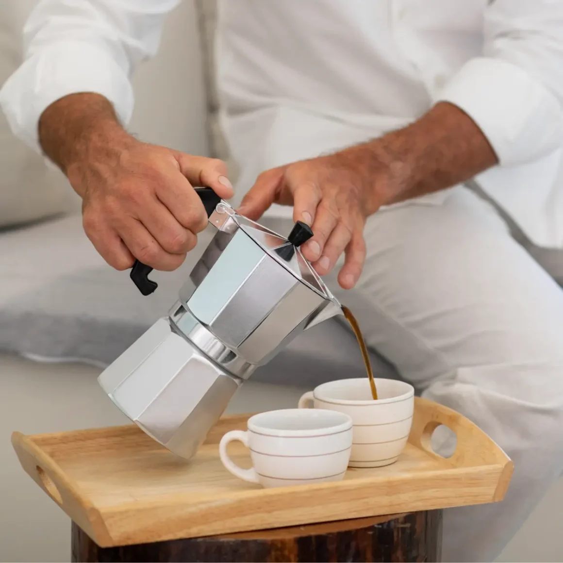 barista pouring coffee into cups from a moka pot