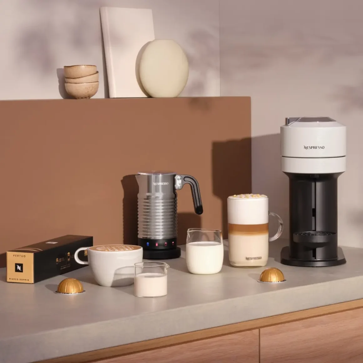 a nespresso machine and cup of milk on a counter