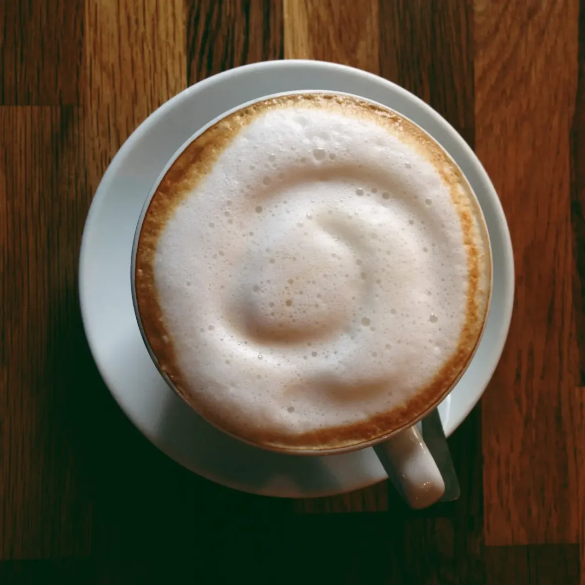 a cup of hot latte on a saucer