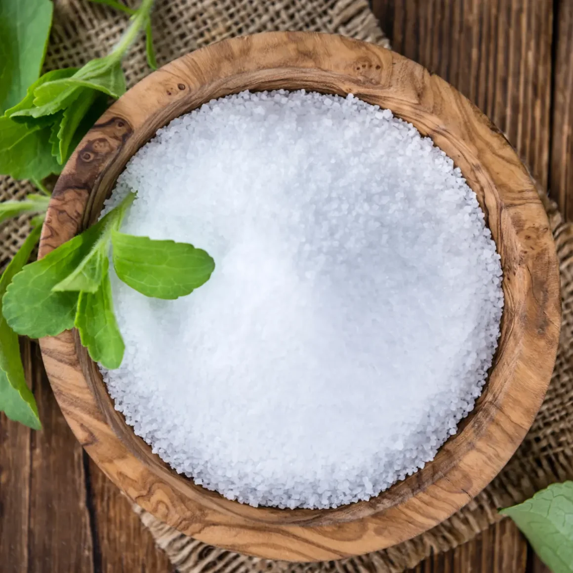 a bowl of stevia sugar with leaves on a table