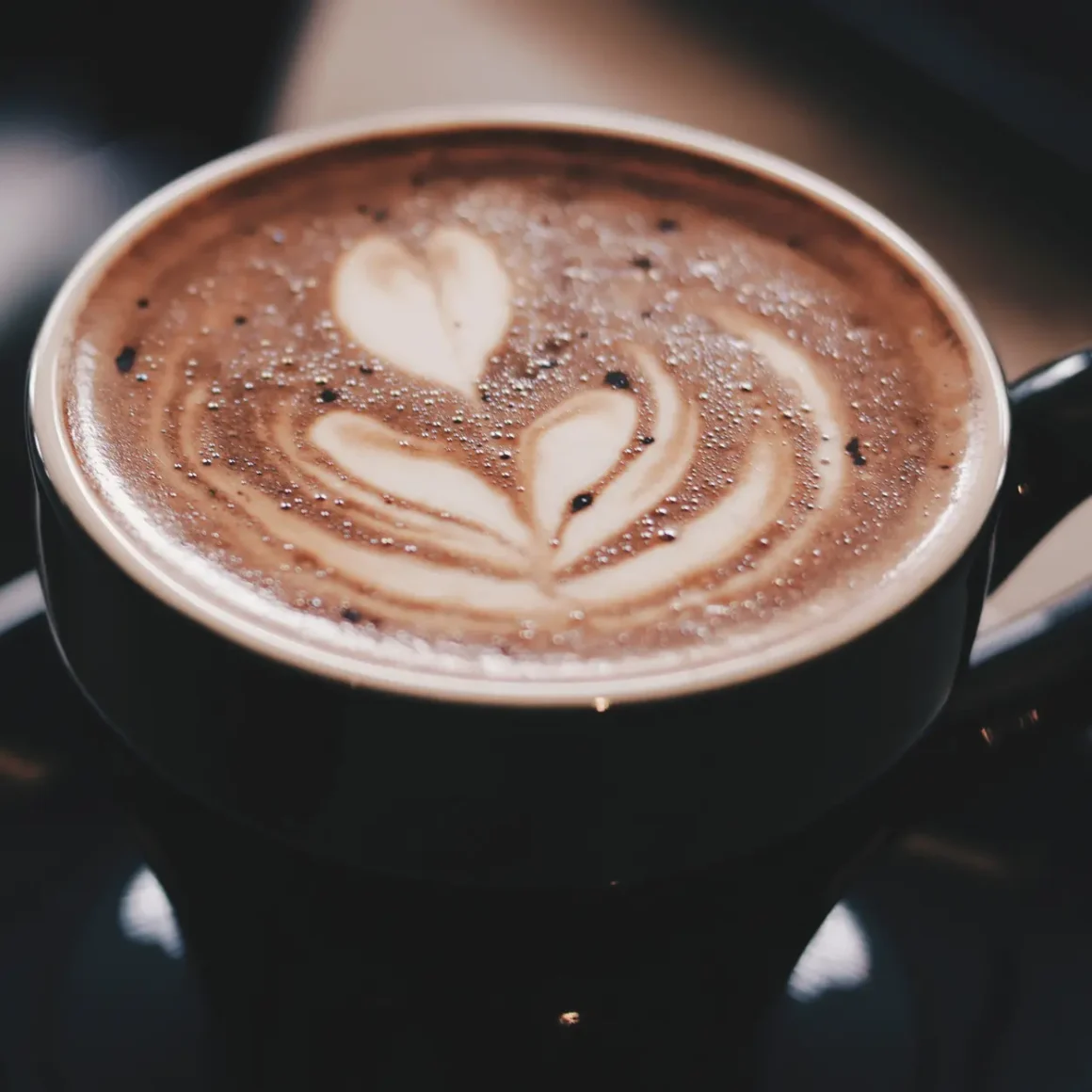 a cup of mocha with a heart design in the foam