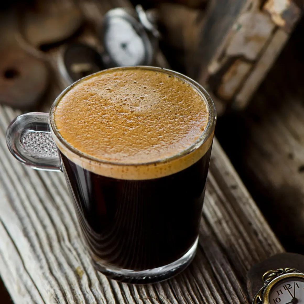 a glass cup of double espresso with foam on top