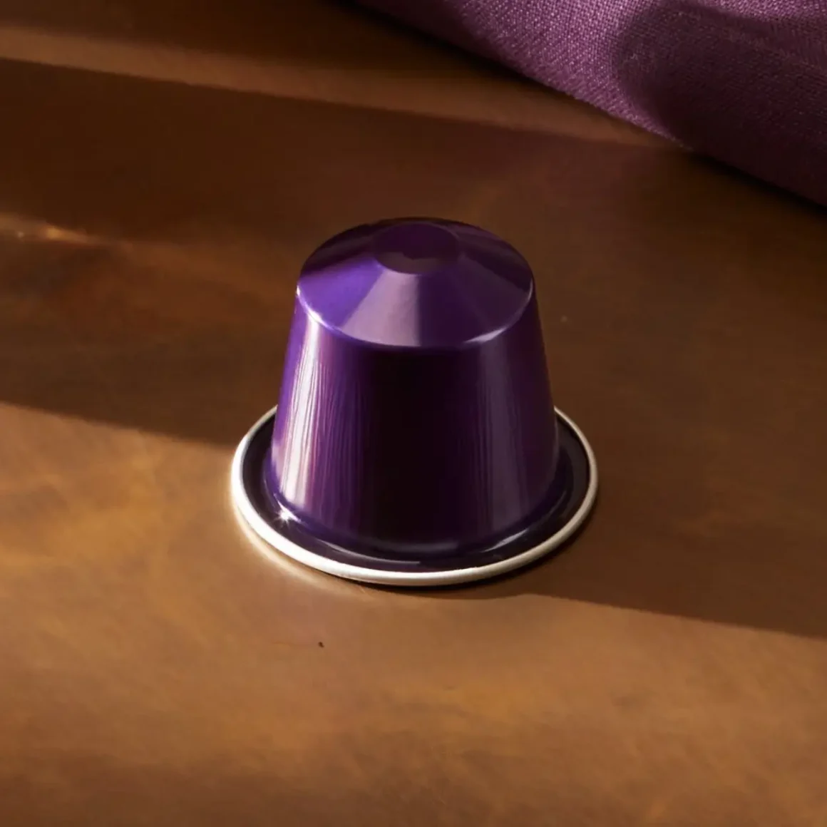 a purple coffee capsule on a brown surface