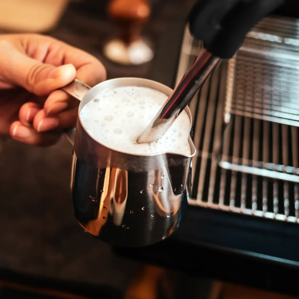 a person holding frothing milk