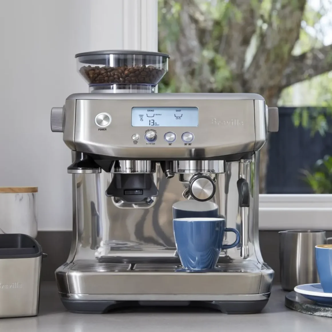 a breville barista pro espresso machine with cups on a counter