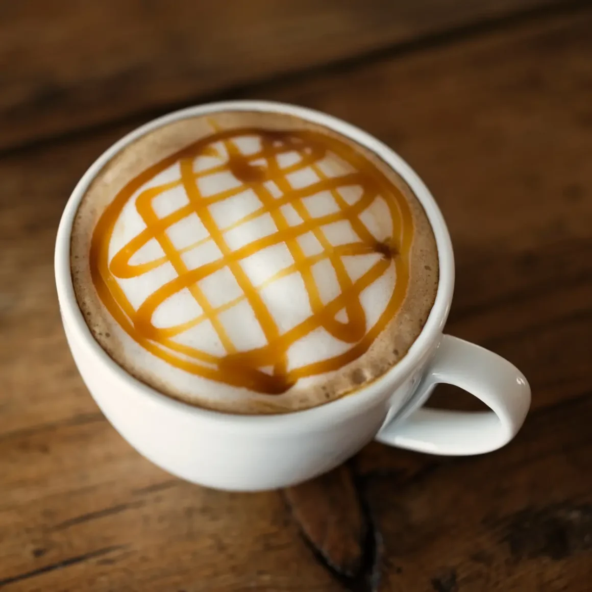 a cup of vanilla caramel coffee with a design on top