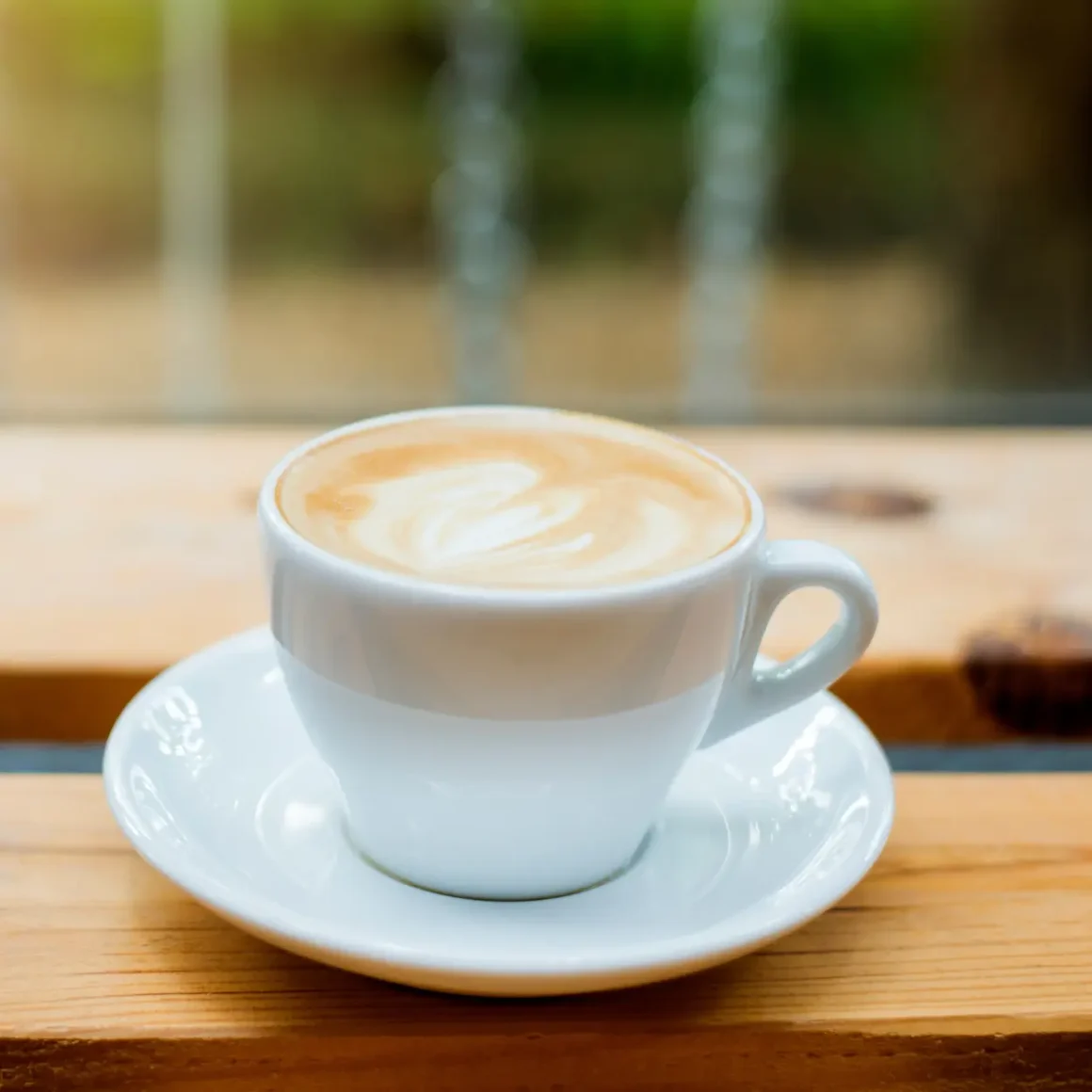 a cup of hot latte on a saucer