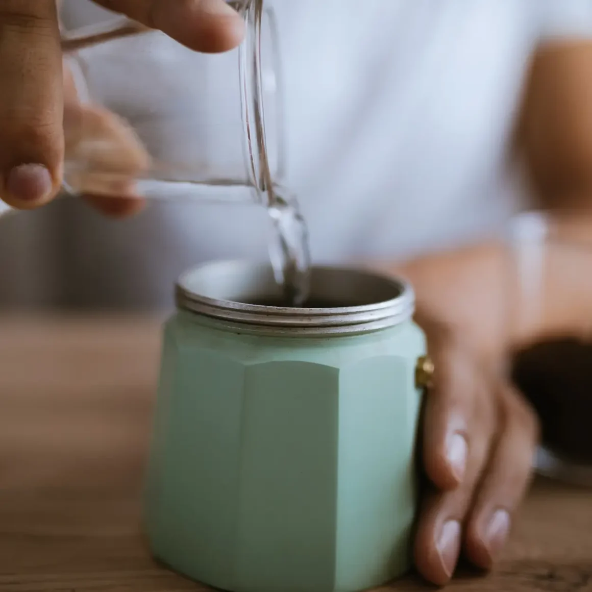 barista pouring water into a cup