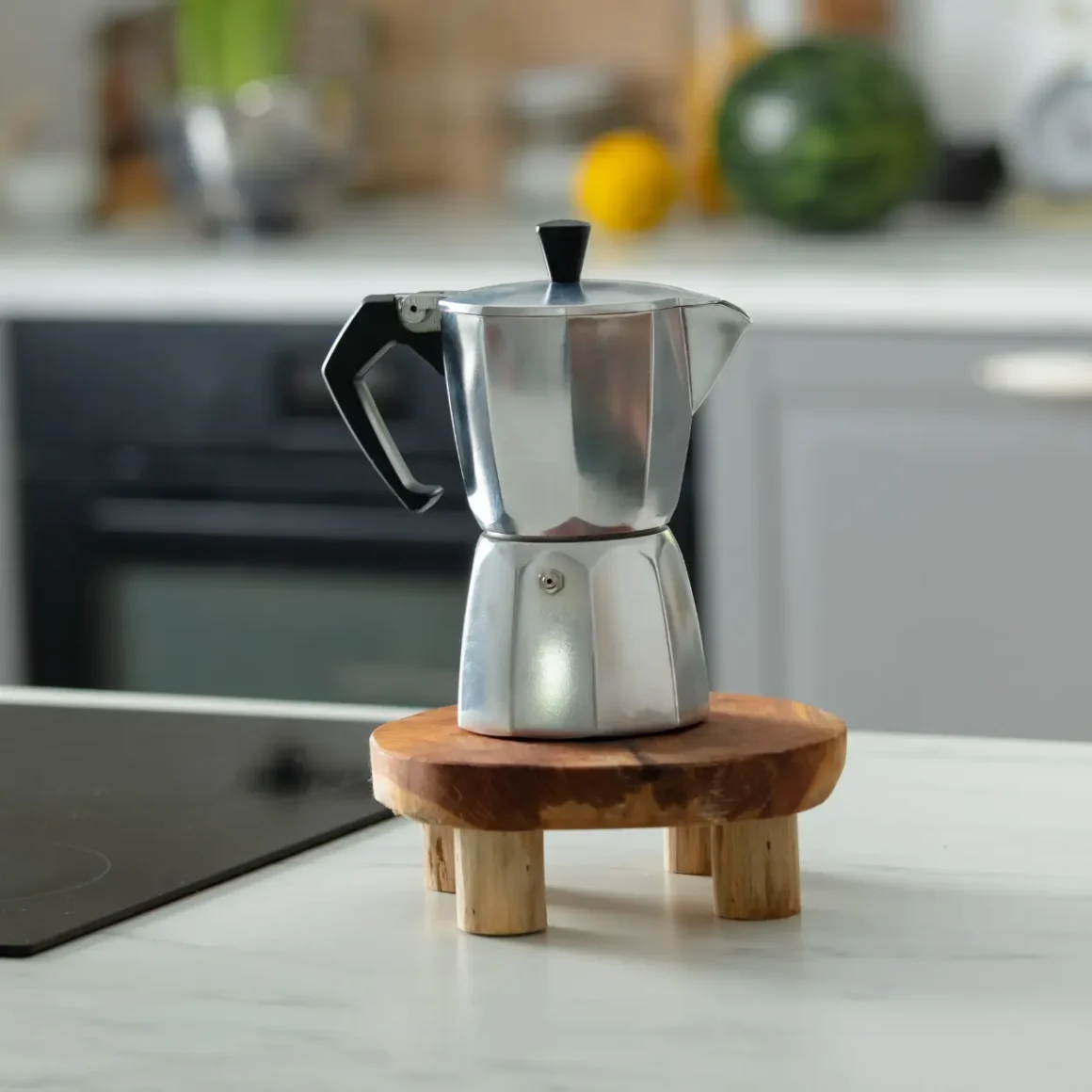 a silver moka pot on a wood stand