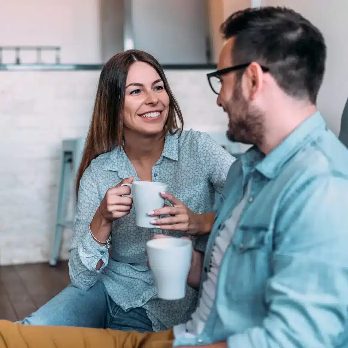 a woman and man holding cups of coffee