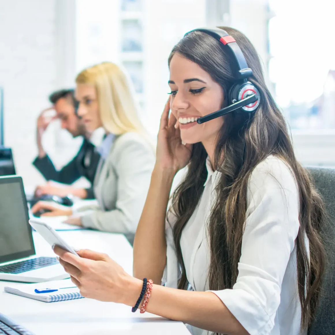 a woman wearing a headset and looking at a phone