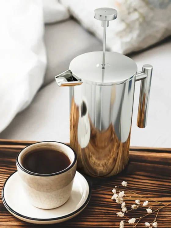 a utopia kitchen chrome double wall french press coffee maker and a cup of coffee on a tray