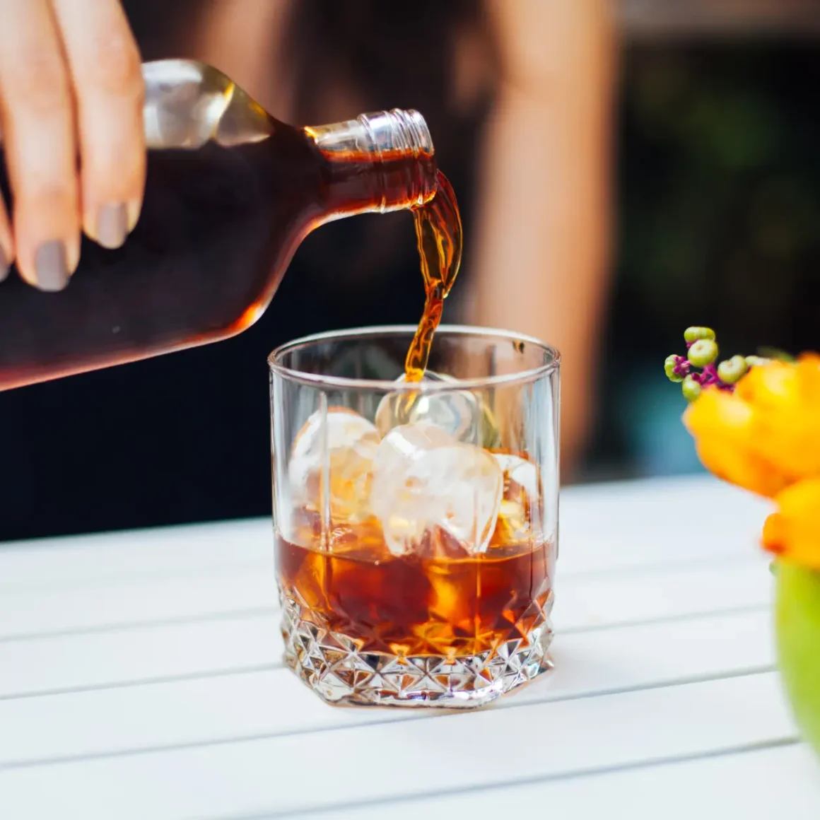 a person pouring a cold brew coffee into a glass