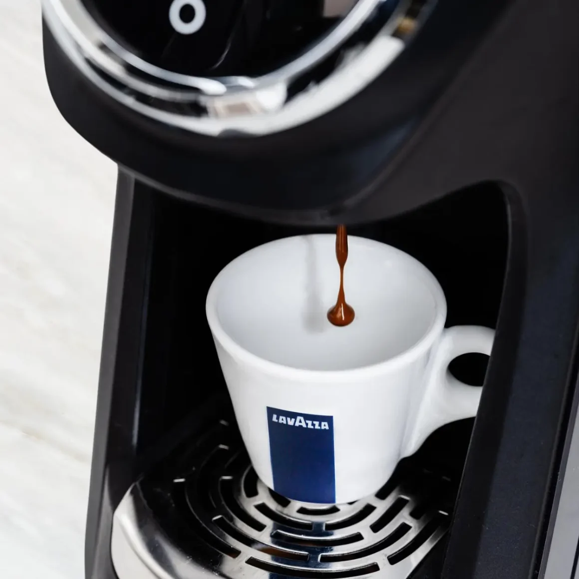a lavazza blue classy mini coffee maker with a cup of coffee