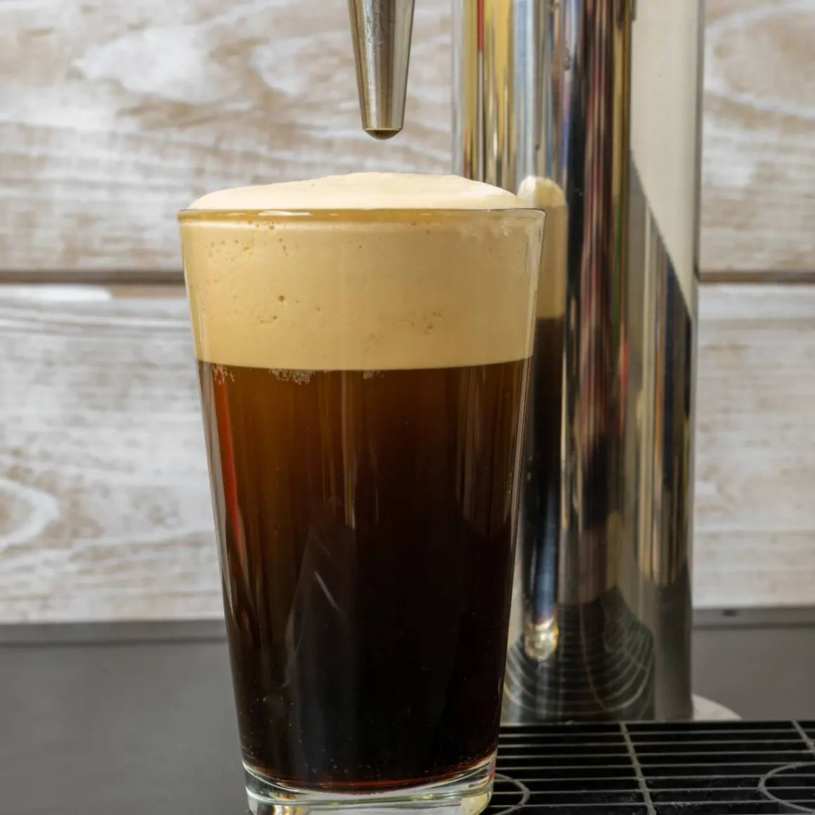 a glass with a nitro cold brew coffee and foamy top