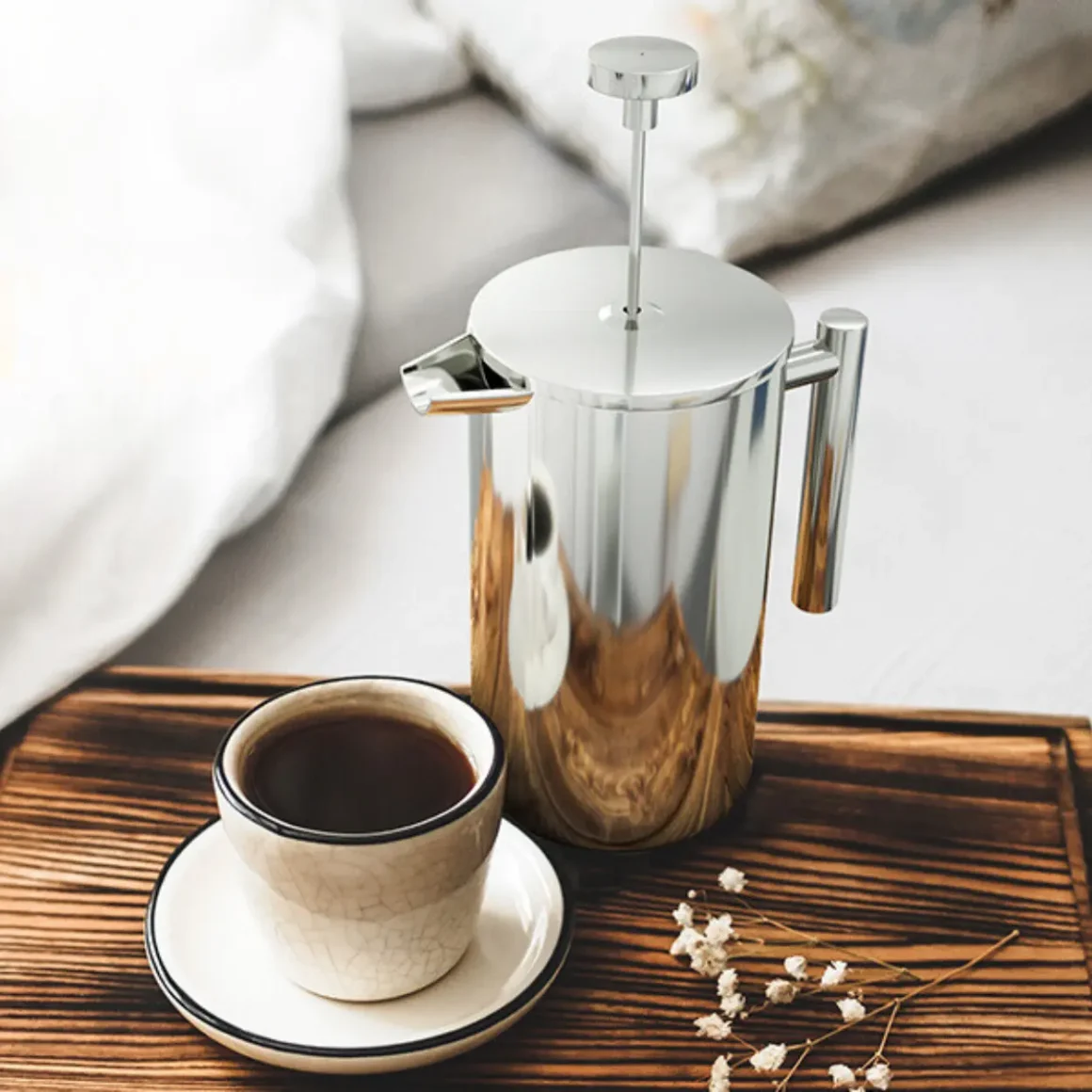 a utopia kitchen chrome double wall french press coffee maker and a cup of coffee on a tray