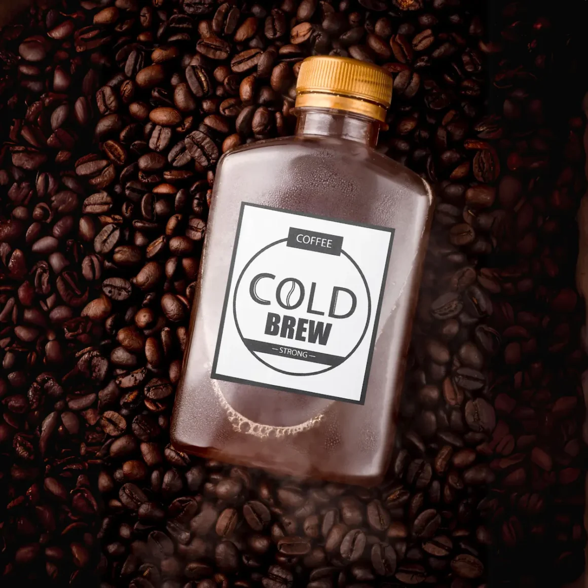 a bottle of cold brew coffee on a pile of coffee beans